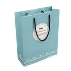 Luxury paper shopping bag with rope handle and ribbon bow for retail store