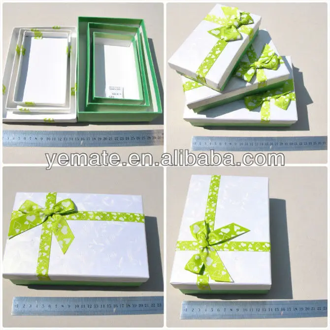 white cardboard paper gift packaging box with green ribbon on