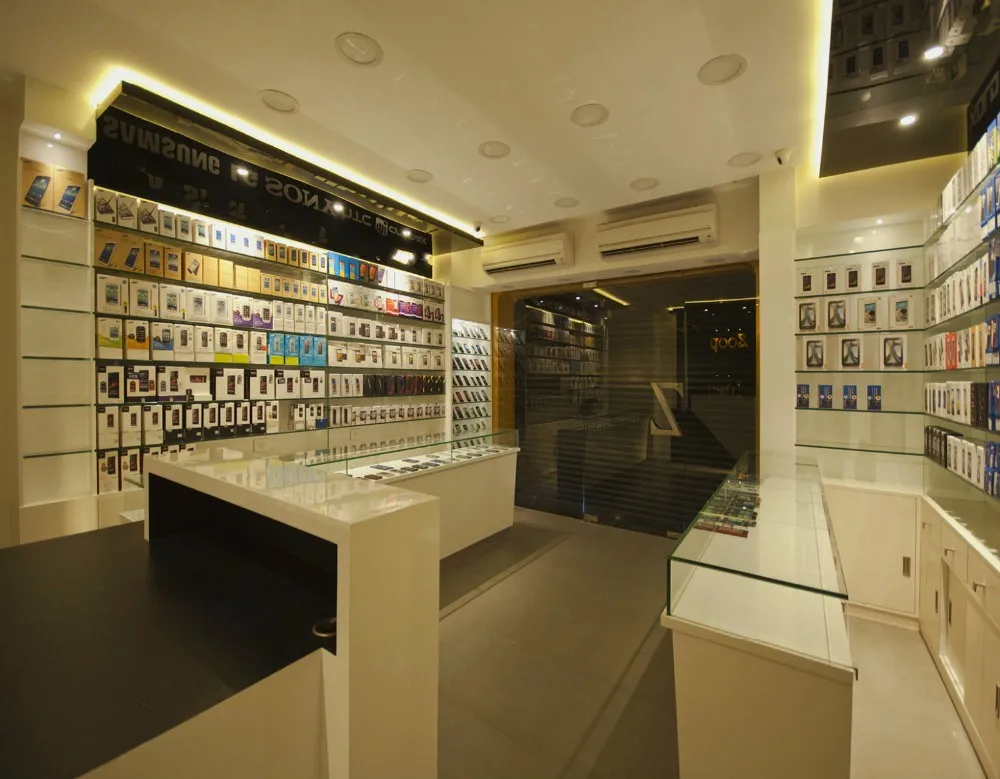 Small Warm Decorated Mobile Phone Shop Interior Design With Glass Accessories Display Shelves And Counter View Mobile Phone Shop Interior Design