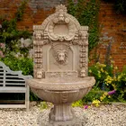 beige stone carved marble wall fountain with lion head