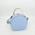 round case shape with front oriental floral print fabric and top flat chunky handle hardware handbag