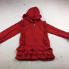 The girl wore a hat, coat and skirt with a zipper design that ruffled three edges on one side