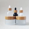 /product-detail/wholesale-new-design-30ml-50ml-100ml-cosmetic-frosted-glass-jar-with-bamboo-lids-60699095426.html