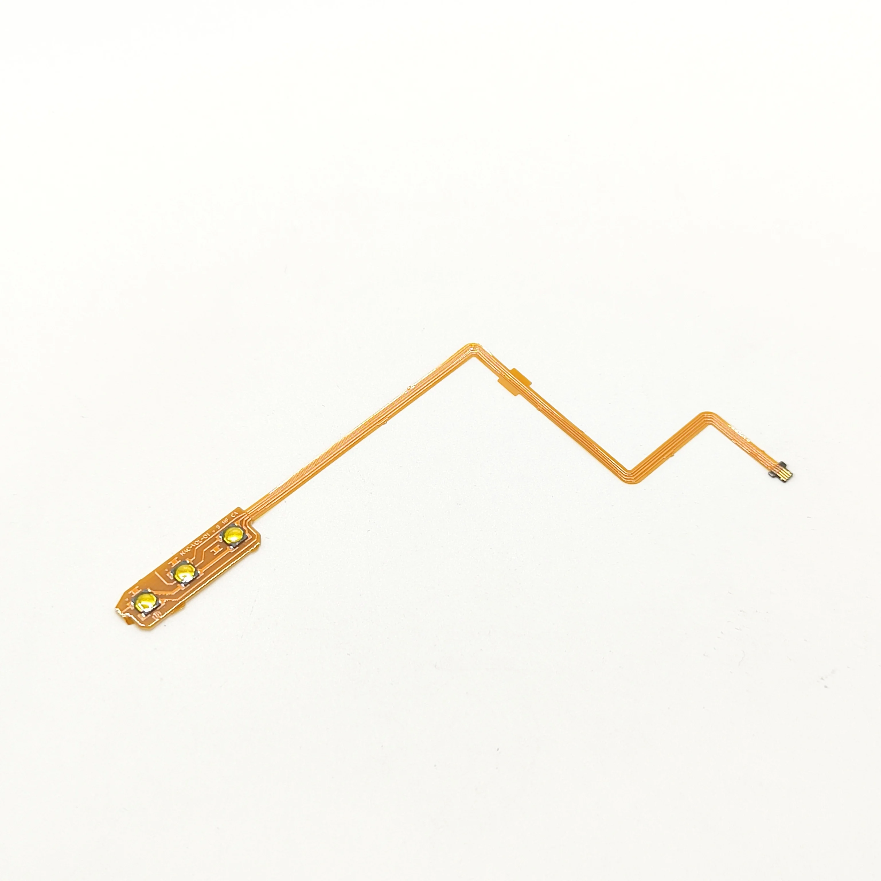 Close-up of power button flex cable showing gold-plated contacts and polyimide substrate