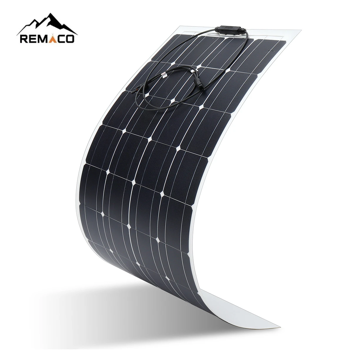 Foldable 100W solar panel laid open on grass, showing ETFE surface and integrated kickstand