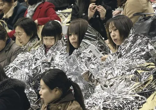 a_group_of_women_wrapped_in_emergency_blankets
