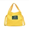 Candy-colored bucket bag original canvas label slanted across bag art and easy to carry handbag