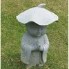 carved stone little monk statue with a lotus leaf on head