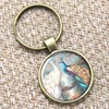 Peacock keyring, a very large tail covered with blue and green spots, which it can spread out like a fan keyring