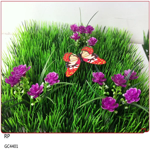 廉价的天然人造草地毯与花的花园装饰