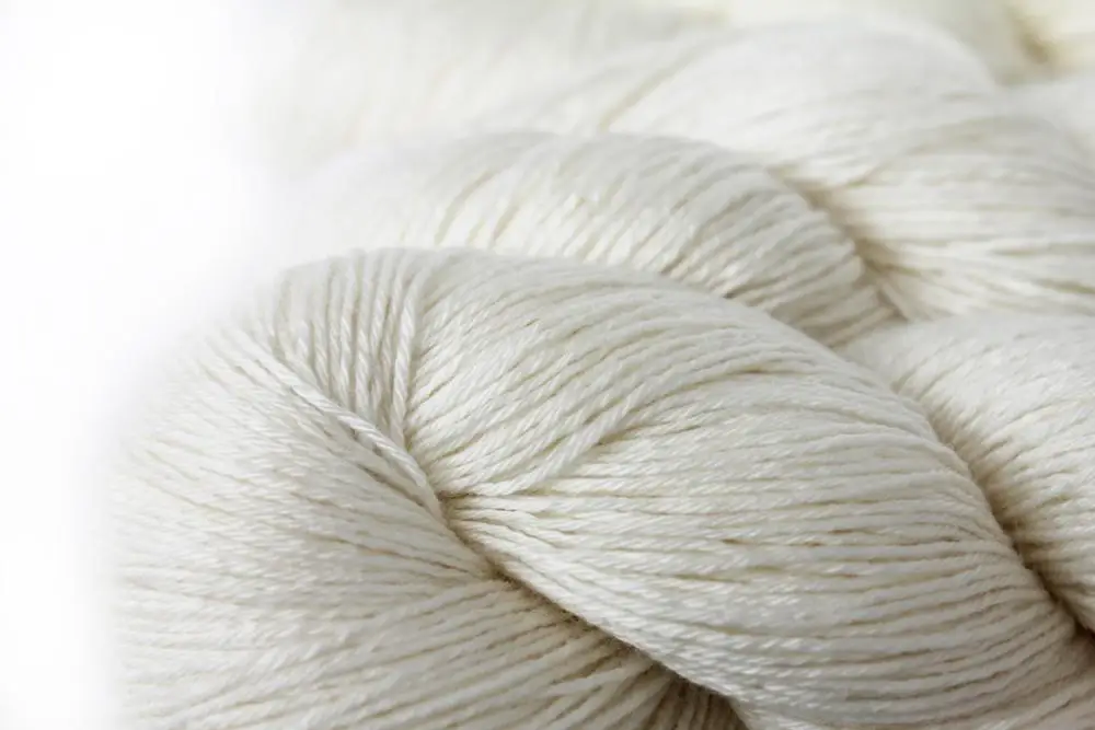 Merino wool. Пряжа шерсть неокрашенная. Нитки натуральных оттенков. Белая пряжа из мериносовой шерсти. Шерсть мериноса фон.