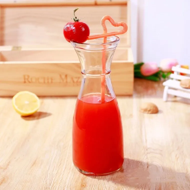 clear glass juice beverage bottle with colorful straws
