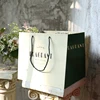 Custom logo hot selling plain cheap brown paper bag with rope handle and bow for clothes garments bra dresses shirts packaging