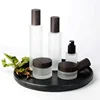 wooden cap dark wood grain empty cosmetic packaging clear frosted glass bottle and jars with water transfer dark wooden lid