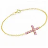 yellow gold tiny cross chain bracelet with pink cubic zircon