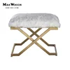 faux fur in soft white atop legs of thick industrial hand forged iron finished ottoman