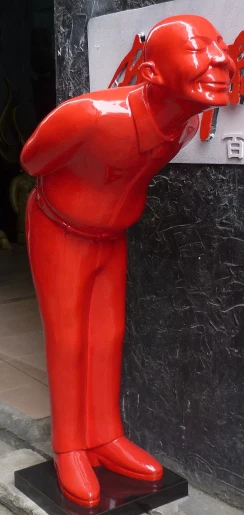 red bowing man sculpture