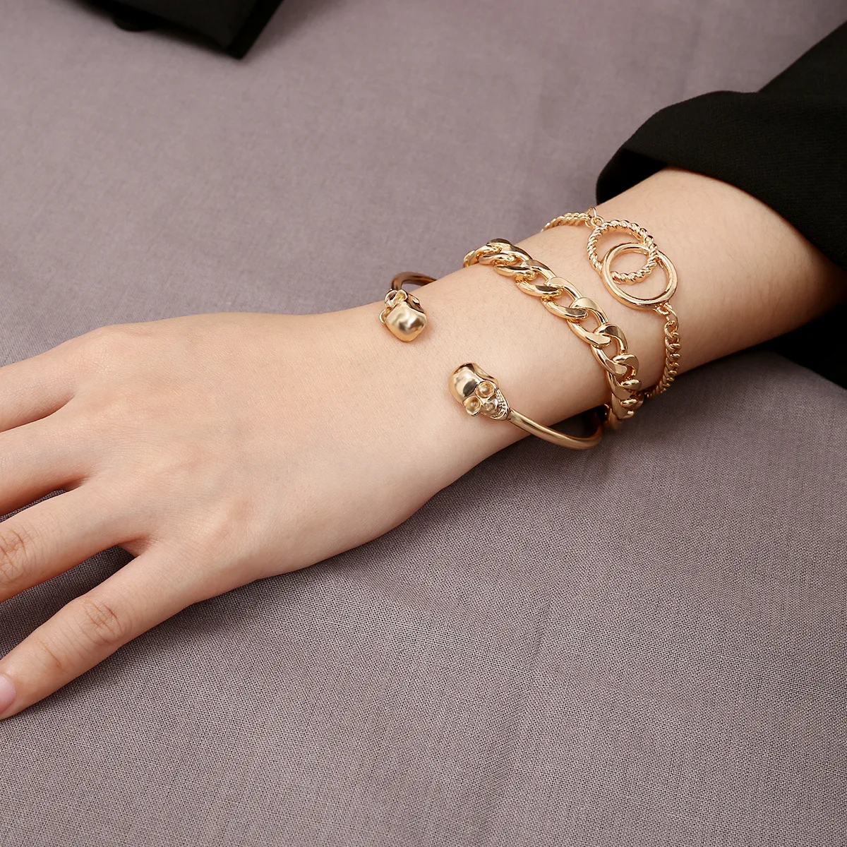 Несколько золотых браслетов на одной руке