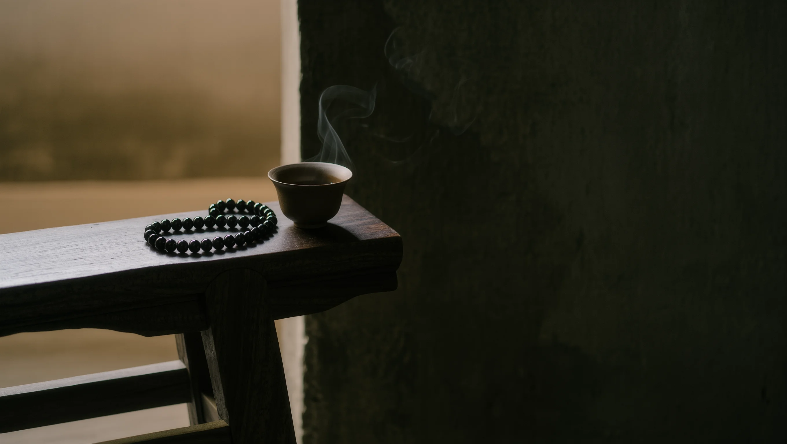 Contact Us 1 Sovereign Stillness Jewelry Contact: A handcrafted obsidian relic and a steaming vessel of tea, symbolizing the clarity of direct communication.
