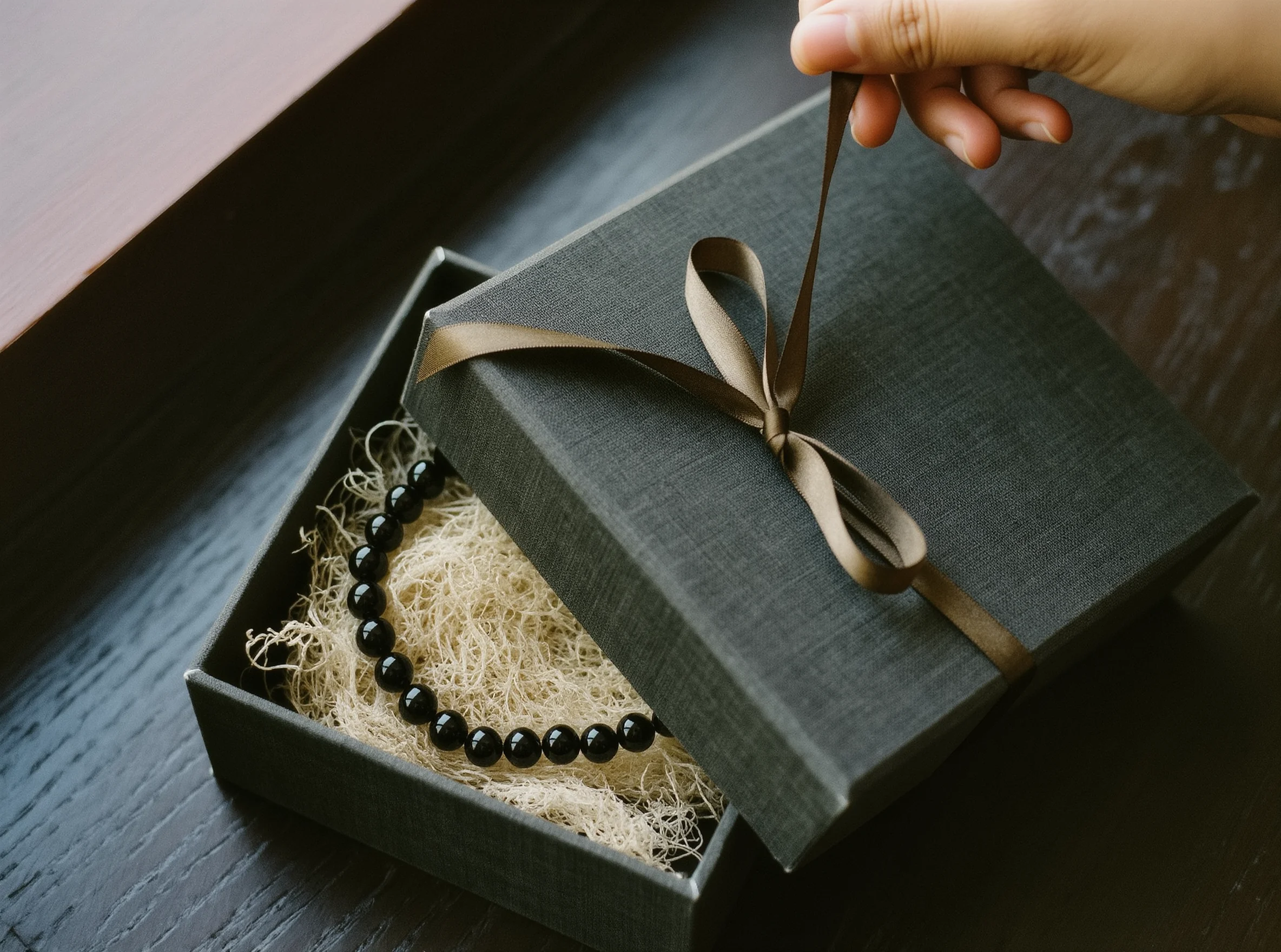 The Gift of Grace: Why We Exchange Sacred Tokens 2 Sacred Token by Yuano: A handcrafted obsidian necklace in a luxury charcoal gift box