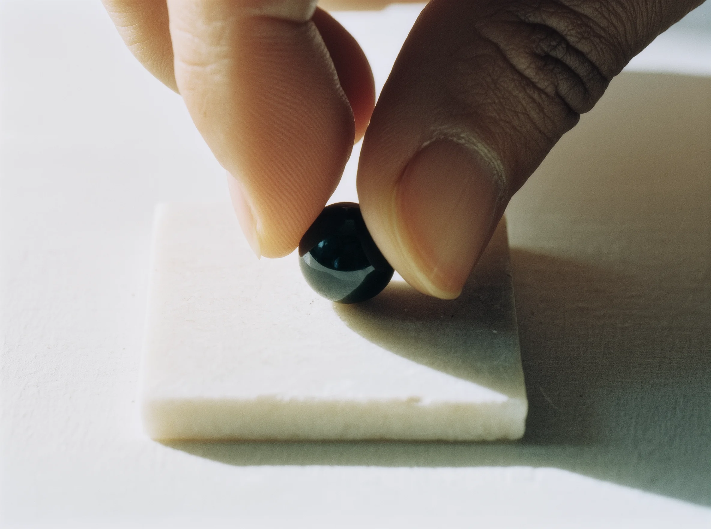 The First Stone: Marking the New Beginning in Grace 2 The First Stone by Yuano: A sacred obsidian bead being placed on a white stone base